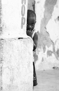 Boy hiding behind a tree